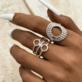 Detailed view of silver irregular geometric rings on hand with textured stone background - Hammered Wave + Double Circle Style (6210) / Stainless Steel Color (2-Piece Set)