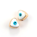 Close-up of golden heart-shaped evil eye enamel pendants for DIY jewelry making - 10pcs White Evil Eye Heart Beads
