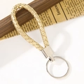 Portachiavi in pelle intrecciata oro champagne con anello in metallo lucido - Oro