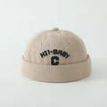 Detailansicht der beigen Cord-Beanie mit schwarzer HI!-BABY und C Buchstabenbestickung - Kleinkindgröße / Khaki