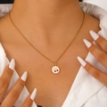 Close-up of a model wearing a gold stainless steel necklace with a red cherry enamel pendant - Round Cherry Style (DZ-425)
