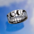 Macro di un anello largo in acciaio inossidabile con incisioni nere di luna e stelle - US 7 / Anello Cielo Stellato