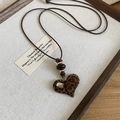 Primer plano del colgante de corazón de leopardo con cristal en collar de cuero - Estilo de Corazón de Leopardo Con Cuerda Marrón Oscuro