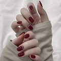 Short square-oval burgundy press-on nails with matte finish and pearl accents on hands - Glue Type