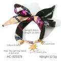 Dettaglio di gioielli in sciarpa di seta con ciondoli dorati a forma di cuore e sole - Bracciale Stampa Multicolore Sole Cuore (HC-B20378)
