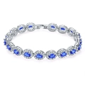 Macro detail of silver bracelet featuring oval blue stones with diamond-like halo accents - Platinum Blue Zirconia