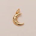 Macro shot of 14K gold plated crescent moon pendant with three clear zircon gemstones - Moon