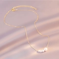 Detail of elegant gold pearl necklace with five gradient pearls on purple silk fabric - 7# Necklace. Faux Pearl Necklace (Five Gradient Pearls)