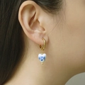 Detail of heart-shaped blue and white porcelain earrings on a model with golden hoops - Heart Blue Porcelain