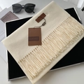 Elegant cream cashmere-feel scarf with long tassels and leather label on black tray - Milky White 4.6cm