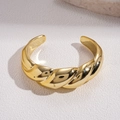 Macro-opname van een minimalistische gouden gedraaide armband met gepolijste spiraalvormige textuur - Gedraaid Touw Stijl / Goud