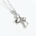 Minimalist silver bow necklace pendant with high-polished metal finish on white background - Irregular Knot (Silver)