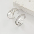 Detail of silver ear clips with pearl and diamond inlays on a white stone background - Pearl Zirconia Ear Cuffs - Silver (EP5619)