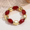 Detalle de pulsera bohemia con cuentas doradas y cuentas de acrílico rojo brillante - Rojo