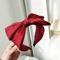 Detailed close-up of a large red satin bow headband with elegant silky fabric texture - Burgundy
