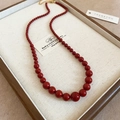 Détail du collier de perles rouges avec fermoir mousqueton doré et chaîne réglable - Collier-Fermoir Doré-Rouge