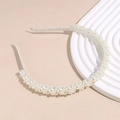 Macro detail of the elegant faux pearl headband with dense luster beads and ivory satin wrap - White
