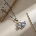 Close-up of silver cherry necklace featuring bow knot detail and sparkling zircon stones - Silver Cherry