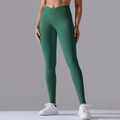 Detail view of the V-cross high waist and ribbed texture on dark green yoga leggings - Dark Green