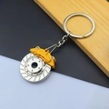 Macro shot of a yellow brake caliper and silver disc keychain for car enthusiasts - Brake Disc / Yellow