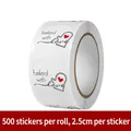 Macro view of 500-count Baked with Love round stickers, 2.5cm diameter on a white roll - Baking Heart Baked With Love (C59)