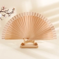 Minimalist wooden folding fan in natural finish displayed on matching wood stand - Natural