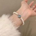 Elegant pearl bracelet with a blue gemstone centerpiece and rhinestones on the wrist - Blue Gemstone Pearl Silver Border (MY35575)