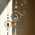 Golden suncatcher with purple stones and colorful crystal prisms reflecting rainbow light - Amethyst