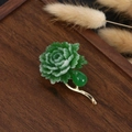 Detalle macro del broche de flor china en verde y dorado sobre fondo de madera oscura - Diseño Floral Verde