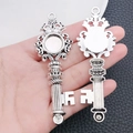 Macro detail of vintage silver heart-shaped key pendant with crown motif in palm - Crown Key Sticker Base (3663)