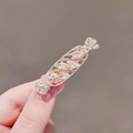 Sparkling pink rhinestone candy hair clip with gold base for elegant side styling - Candy Shape