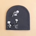 Dark grey knit beanie with pixelated abstract graphic on plain beige background - Gray