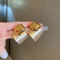 Detail der goldenen geometrischen Ohrringe mit Kontrast zwischen polierter und mattierter Textur - Goldene Raute Ohrstecker (Silberstift)