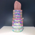 Close-up of lipstick-shaped evening clutch featuring pink rhinestones and colorful crystals - Phantom Pink