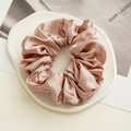 Elegant champagne gold satin scrunchie with glossy silk texture and pleated design - Brown