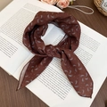 Detailed close-up of a brown paisley silk scarf necklace laid on vintage art books - Coffee-Blue