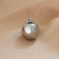 Macro shot of a polished silver round metal pendant with a connector ring on beige fabric - 3# White K-Color Sphere Large