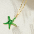 Detailed macro view of 14k gold starfish pendant with green enamel on a cable chain - Xl2921-3. Starfish
