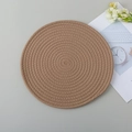 Brown hand-woven round cotton rope heat-resistant place mat on grey desk - Khaki