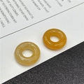 Close-up of translucent amber stone donut beads with natural jade-like texture and finish - Topaz