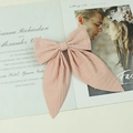 Elegante roze geruite haarknip met lange linten op een romantische papieren achtergrond - Lotusroze