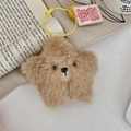 Detail eines sternförmigen braunen Plüschbären-Schlüsselanhängers auf Buchseiten - Kleiner Bär (Dunkelbraun)