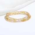 Detailed view of layered gold and silver seed bead bracelets on white textured fabric background - 80cm / Gold/Silver
