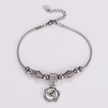Detalle de pulsera de cadena de serpiente plateada con dijes de flores y colas de delfín - Estilo Flor Cola De Delfín / Color Acero