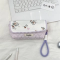 Detail view of a floral quilted pencil case with lavender strap and 'Sozakka' label - Orange Floral + Pink Stripes
