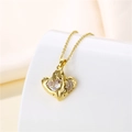 Close-up of a 18k gold heart pendant featuring a large zircon and small accent stones - Gold