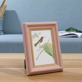 Pink vintage photo frame with hummingbird illustration on light wood table - Pink