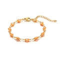 Detail of gold evil eye bracelet featuring orange enamel charms and adjustable lobster clasp - Orange