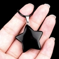 Polished black obsidian star pendant with silver clasp and cord on a dark background - 30mm Obsidian