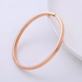 Minimalistischer polierter Armreif aus Titanstahl in Roségold auf weißem Hintergrund - Roségold